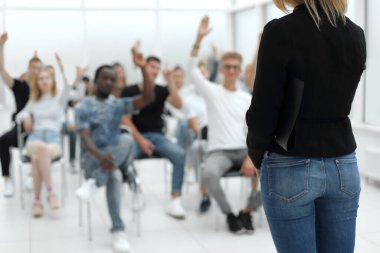 Konferans odasında seyircilerin önünde duran genç bir kadın.