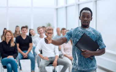 Genç adam iş kursunun öğrencilerinin önünde duruyor.