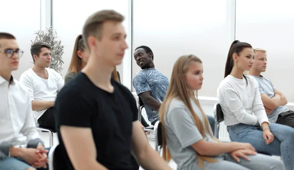 Diverse jongeren applaudisseren terwijl ze op dezelfde rij zitten — Stockfoto