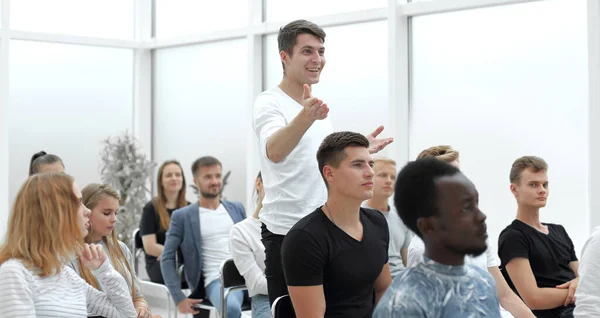 Junger Mann stellt bei einem Wirtschaftsseminar eine Frage — Stockfoto