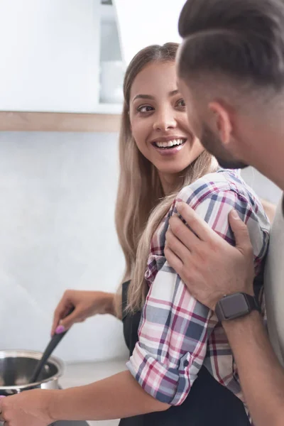 Jovem brincando com sua esposa na cozinha — Fotografia de Stock