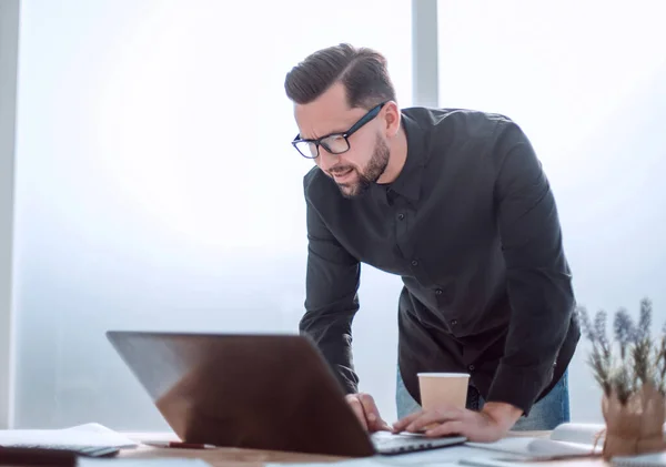 Hombre de negocios mira cuidadosamente la pantalla del ordenador portátil —  Fotos de Stock