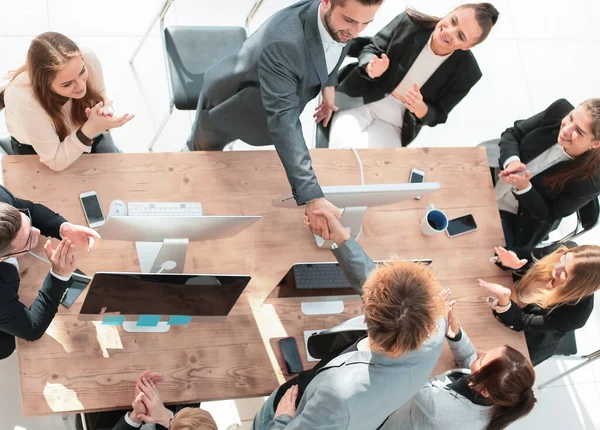 Vista superior. equipo empresarial aplaudiendo en una reunión de trabajo — Foto de Stock