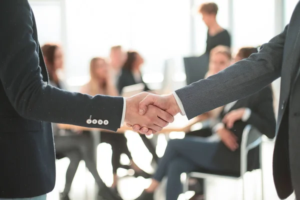 De cerca. apretón de manos de negocios en un fondo de oficina. — Foto de Stock