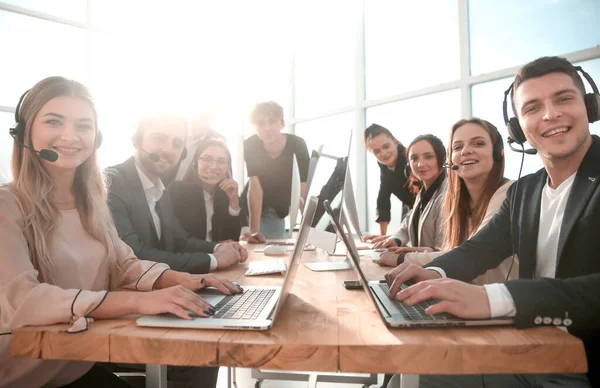 group of mobile cellular operators sitting at a Desk