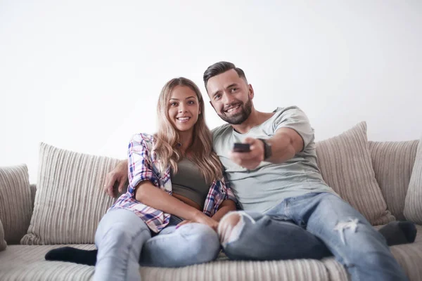 Pareja joven disfrutando en el sofá en el salón — Foto de Stock