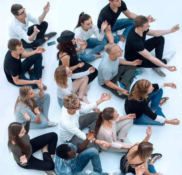 Skupina různorodých mladých lidí meditovat sedí na podlaze. — Stock fotografie