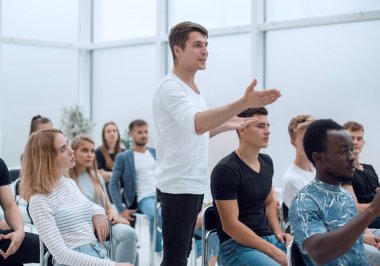 Genç adam bir iş seminerinde soru soruyor.