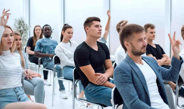 Avslappnad ung man sitter bland seminarielyssnarna — Stockfoto