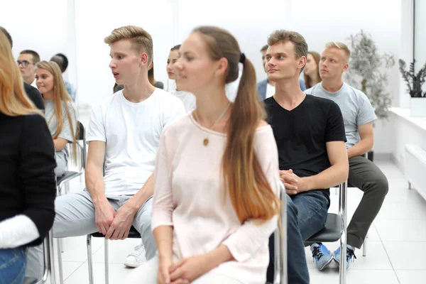 Groep diverse jongeren die in een conferentiezaal zitten — Stockfoto