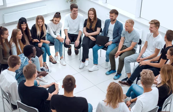 Gran grupo de jóvenes diversos sentados en un círculo — Foto de Stock