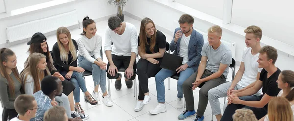 Gran grupo de jóvenes diversos sentados en un círculo — Foto de Stock