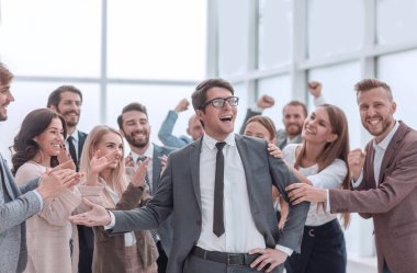 İş arkadaşları arasında duran mutlu bir iş adamı..