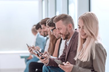 Ofis koridorunda oturan genç iş adamları...