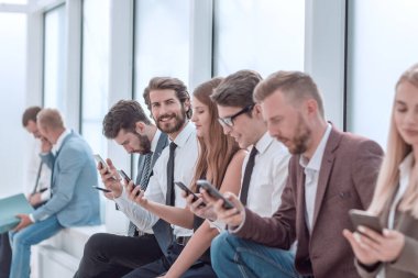 Bir grup genç ofis lobisinde oturuyor.