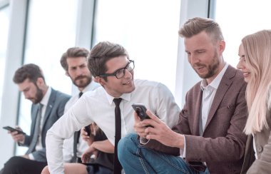 bir grup genç çalışan online haberleri tartışıyor.