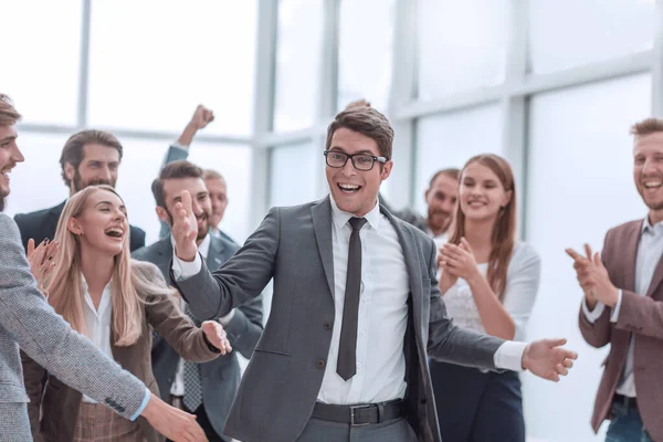 Gelukkige jonge zakenman staan voor zijn business team. — Stockfoto