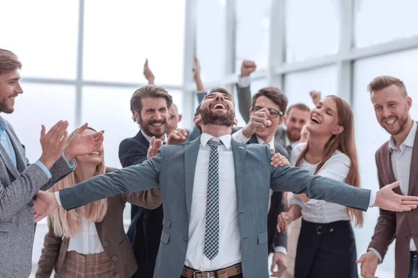 Giovane uomo d'affari allegro che accetta le congratulazioni del suo team di lavoro. — Foto Stock