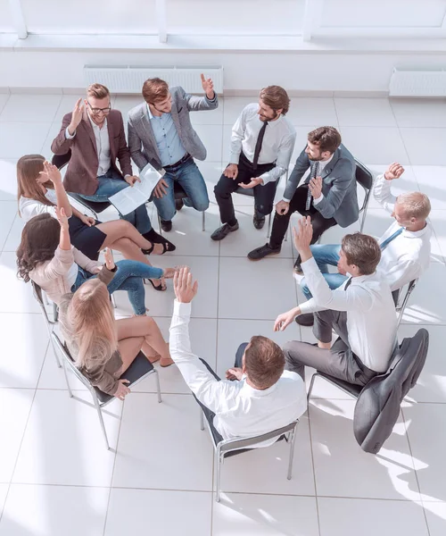 team of young employees sitting in a circle in the conference room .