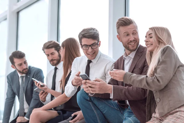 Young employees using their smartphones to view the news online — ストック写真