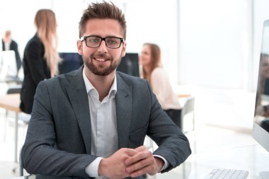 Ofis masasında oturan kendine güvenen bir iş adamı..