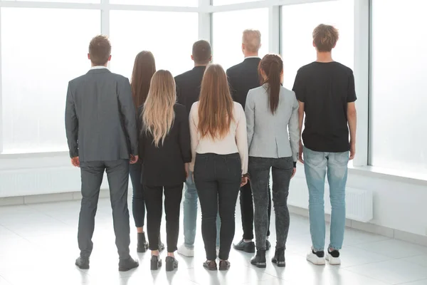 Visão traseira. grupo de jovens empresários olhando pela janela do escritório . — Fotografia de Stock