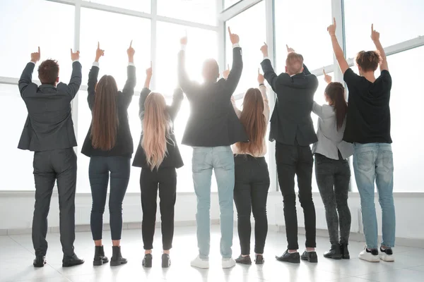 Bakifrån. en grupp affärsmän tillsammans pekar upp på en kopia av utrymmet — Stockfoto