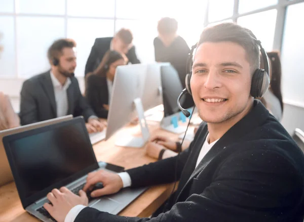Young call center employee sitting at his Desk — Stock Photo, Image