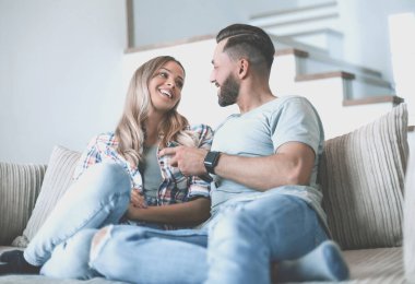 Sıcak oturma odasındaki kanepede oturan sevgili çift.