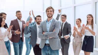 Neşeli iş ekibinin arka planında gülümseyen girişimci