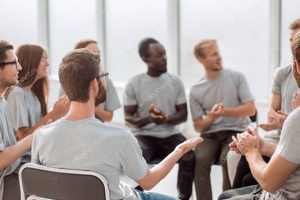 young people are discussing something sitting in a circle.