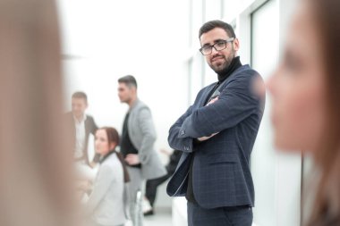 Düşünceli iş adamı ofisinde dikiliyor.