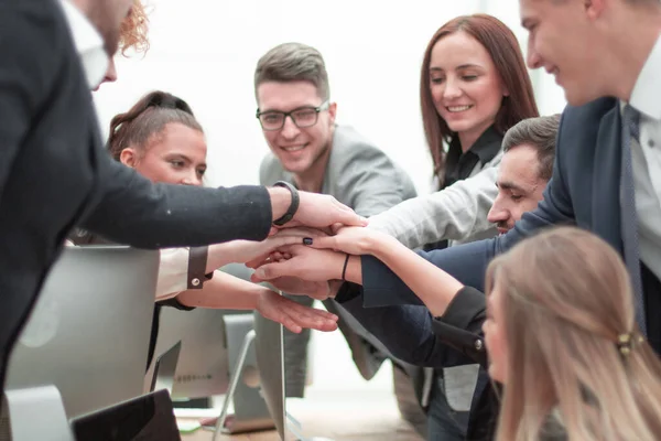 Sonriente grupo de trabajo formando una pila de manos — Foto de Stock