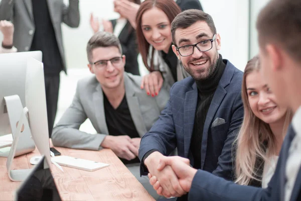 Zakenmensen schudden handen zittend aan het bureau. — Stockfoto