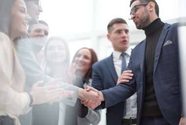 Modern bir ofiste iş ortakları el sıkışıyor..