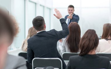 Seminer katılımcıları bir iş toplantısında sorular soruyorlar