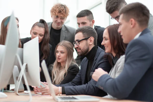 Equipo de jóvenes empleados mirando juntos a la pantalla de un ordenador. — Foto de Stock