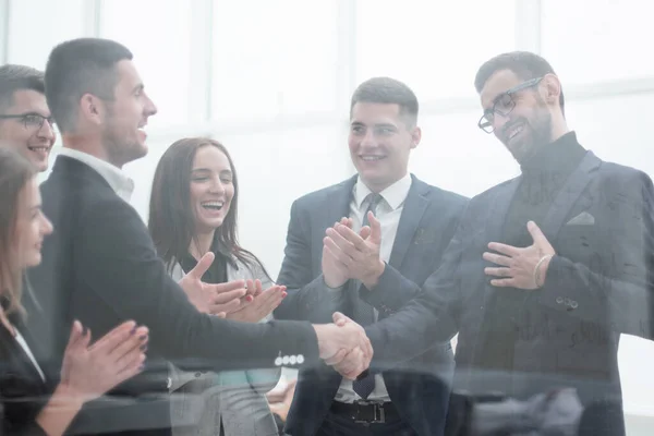 Genom glaset. affärsmän möter varandra med ett handslag — Stockfoto