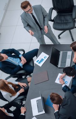 Proje Yöneticisi, iş ekibiyle bir brifing veriyor.