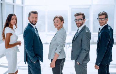 Arka manzara. İş ekibi gülümsüyor ve kameraya bakıyor.