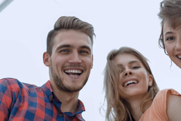 Крупный план трех молодых людей, улыбающихся на белом фоне — стоковое фото