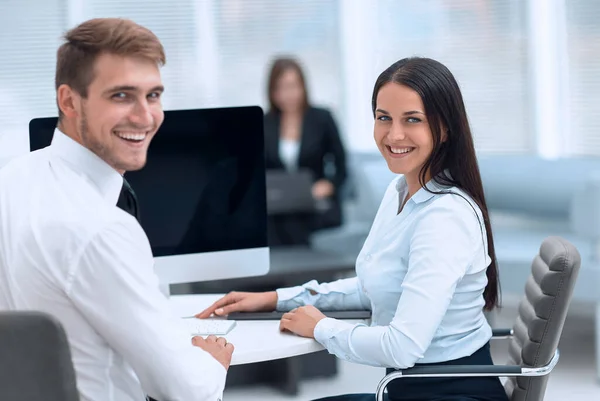 Miembros del equipo de negocios sentados en el escritorio y mirando a la cámara  . — Foto de Stock