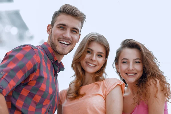Zbliżenie trójki młodych ludzi uśmiechniętych na białym tle — Zdjęcie stockowe