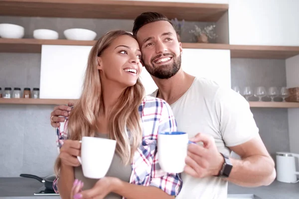 Jovem casal apaixonado na cozinha em um bom dia — Fotografia de Stock