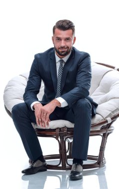 İş adamı rahat bir sandalyede oturuyor.