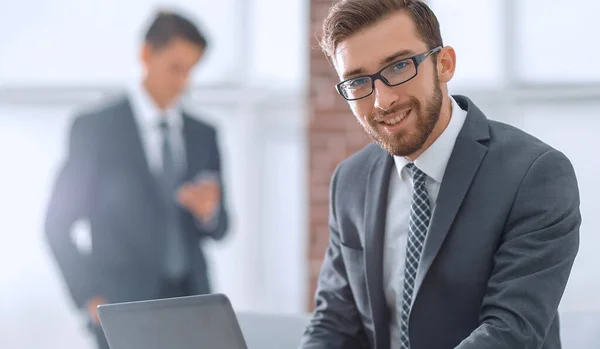 Bonito empresário está trabalhando com laptop no escritório — Fotografia de Stock