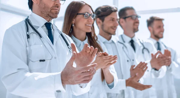 Grupa lekarzy bije brawo, stojąc w szpitalu — Zdjęcie stockowe