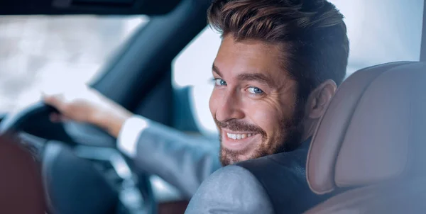 Successful man sitting behind the wheel of a prestigious car — Stock Photo, Image