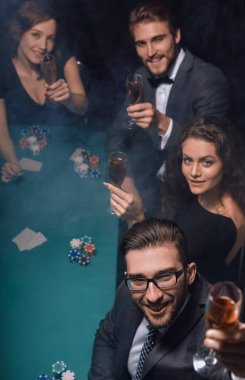 Bir grup genç zengin kumarhanede poker oynuyor.