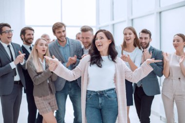 Mutlu kadın lider iş ekibinin arka planında.